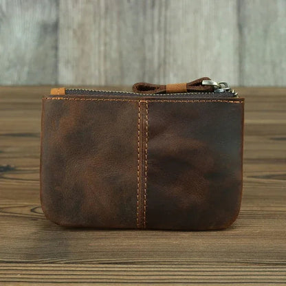 Brown leather coin purse with zipper, front panel seam and metal zipper pull.