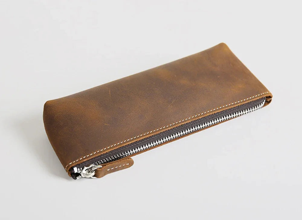 Brown leather pencil case with zip top, metal zipper pull, and contrast stitching