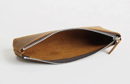 Brown leather pencil case open with silver zipper and empty interior lining