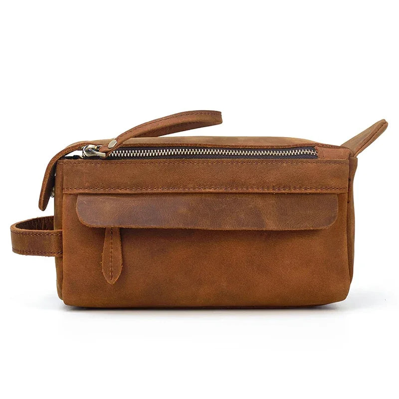 Brown leather toiletry bag with long strap, side loop, and top zip closure