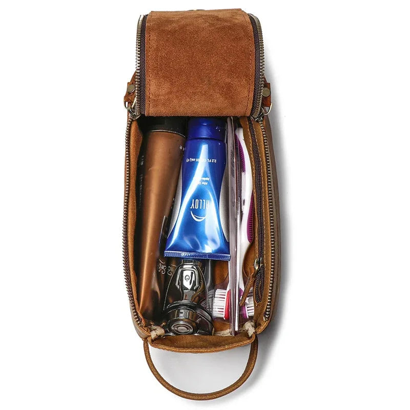 Brown suede leather toiletry bag with top flap, zipper, and loop handle; shows bottles inside.