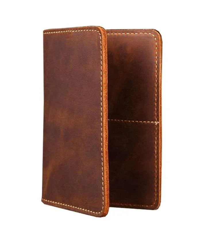 Brown leather passport cover with contrast stitching, closed side view.