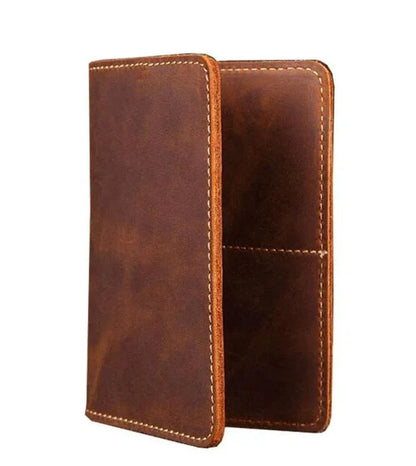Brown leather passport cover with contrast stitching, closed side view.