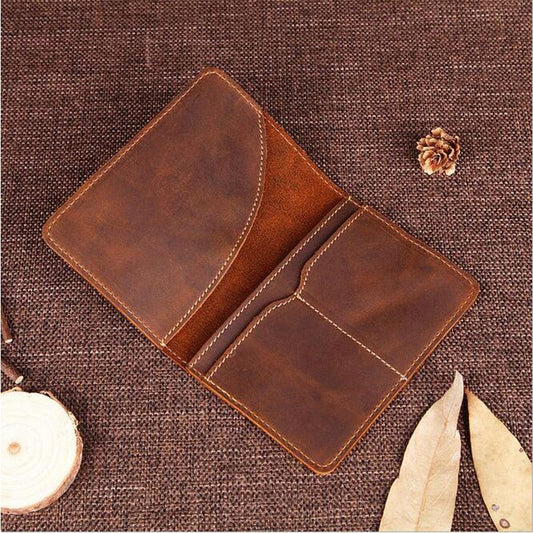 Brown leather passport cover, open with card slots and stitched divider.