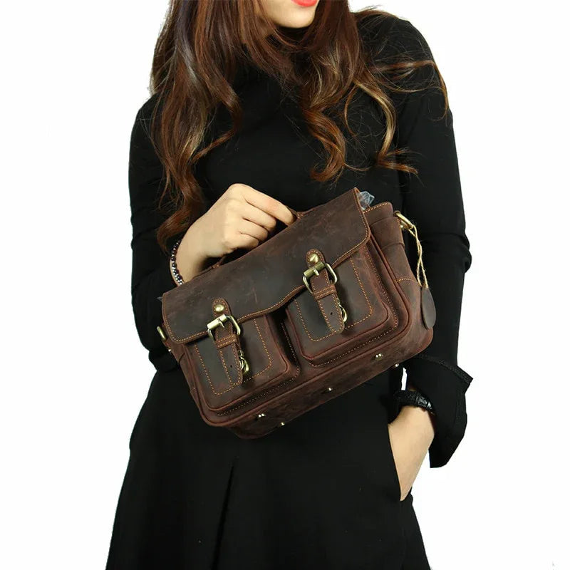 Dark brown crossbody messenger bag carried by model with front buckle flap
