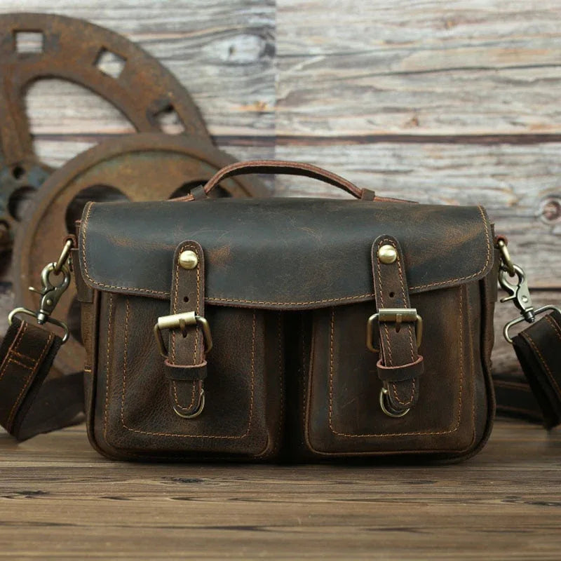 Dark brown leather crossbody bag with front flap, two buckle straps, and side hooks