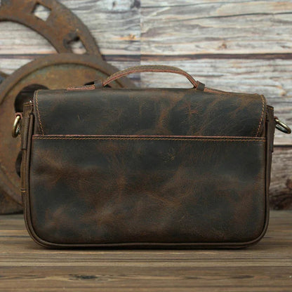 Dark brown leather crossbody bag with flap closure and two front buckle pockets