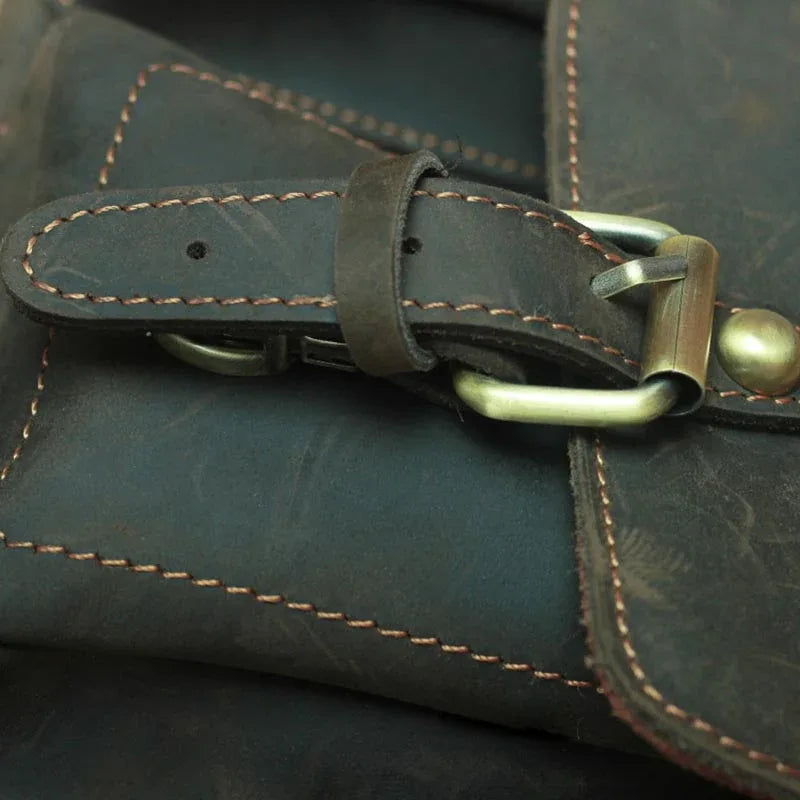 Leather flap strap detail with brass turn-lock and contrast stitching