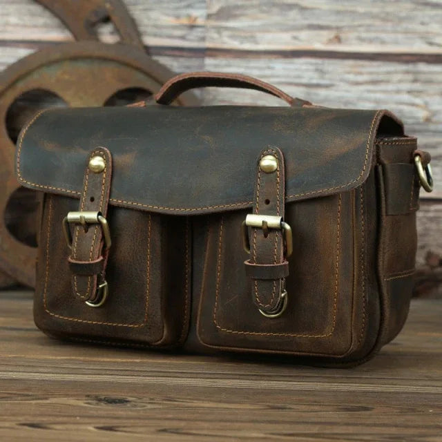 Dark brown leather messenger bag with front flap and two vertical buckle straps