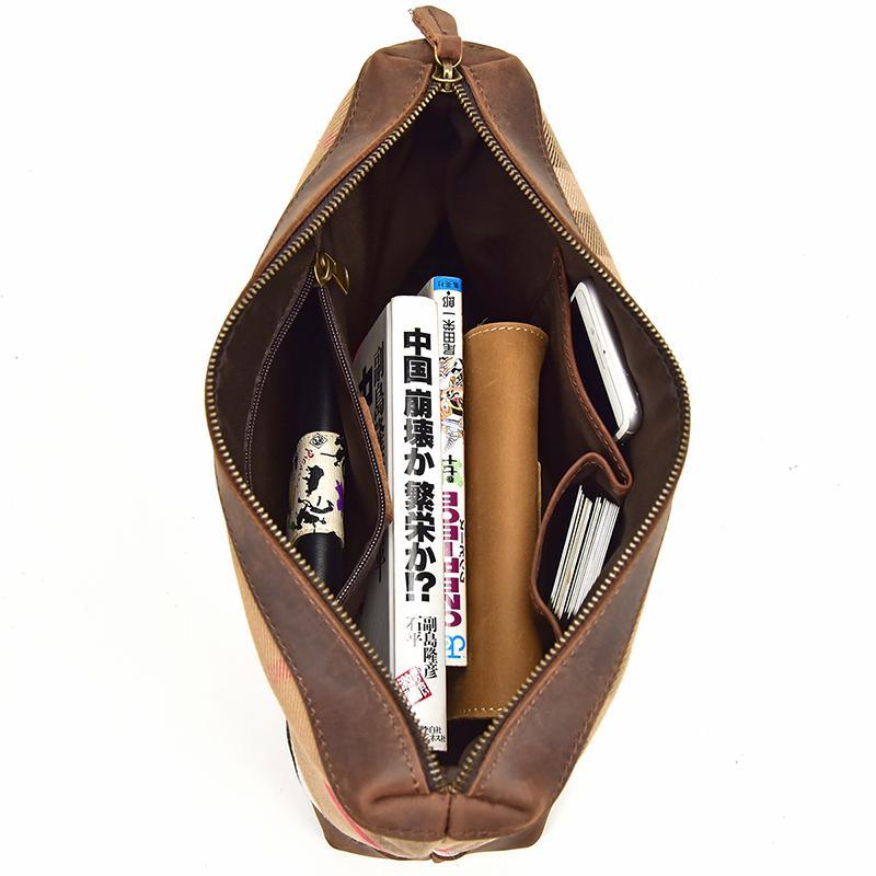 Leather tote bag open at top with visible interior, brass zipper and side slip pockets