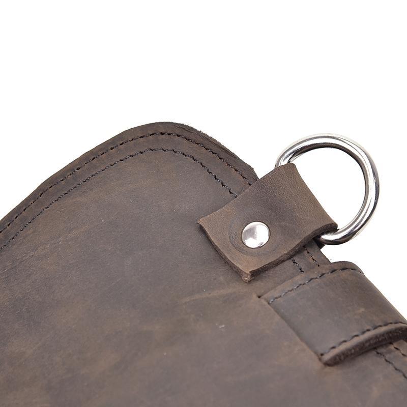 Dark brown leather bag corner with metal key ring and studded strap detail