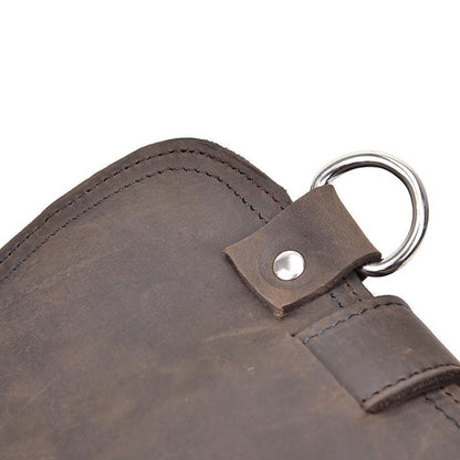Dark brown leather bag corner with metal key ring and studded strap detail