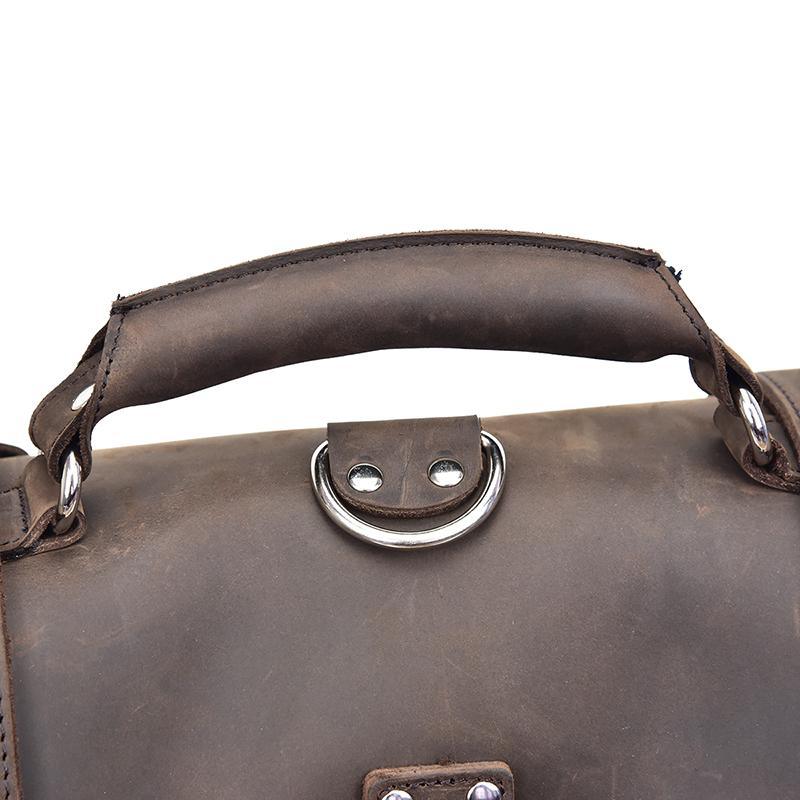 Dark brown leather messenger bag handle with oval metal clasp on top