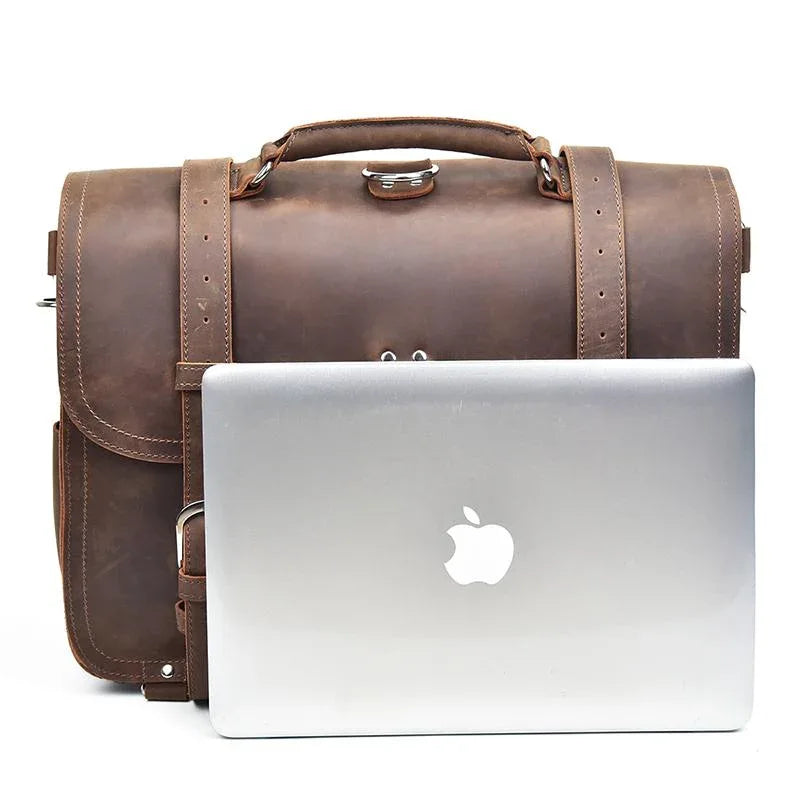 Brown leather messenger bag with laptop in front pocket and adjustable shoulder straps.