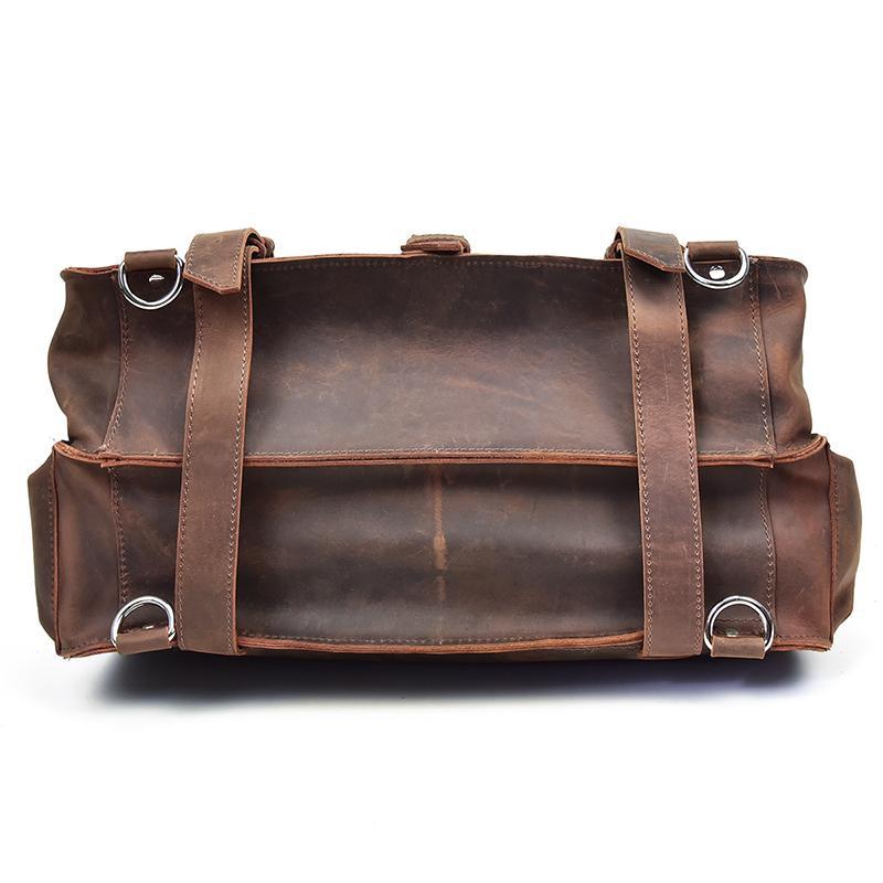Brown vintage leather messenger bag with two top handles and metal ring accents.