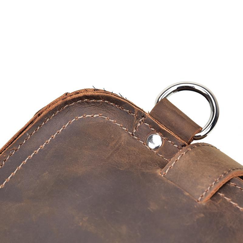 Dark brown leather messenger bag corner with metal ring and stitched trim
