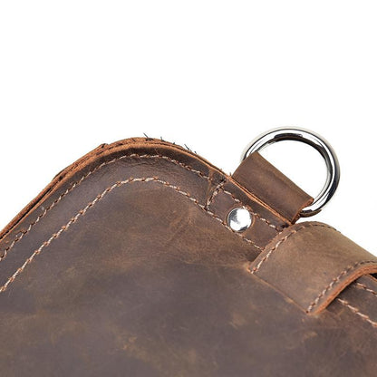 Dark brown leather messenger bag corner with metal ring and stitched trim