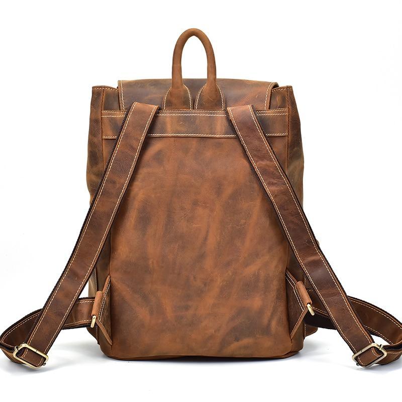 Brown vintage leather backpack with front straps and adjustable shoulder straps.