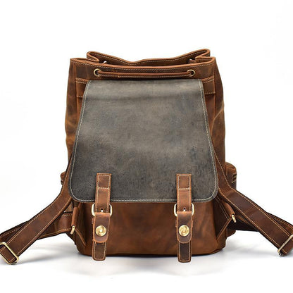 Two-tone leather backpack with gray front panel, brown body, and shoulder straps