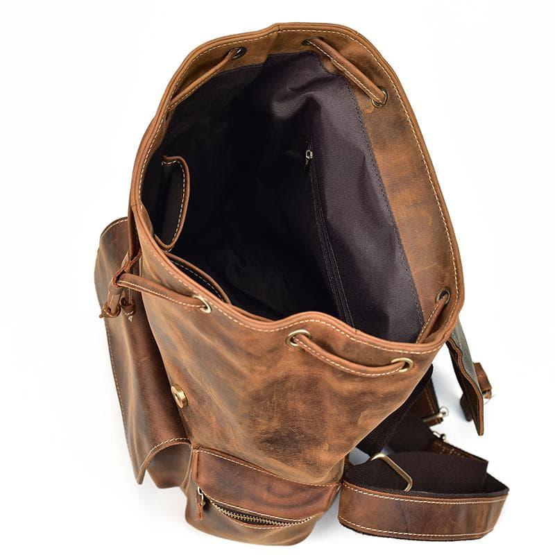 Brown leather backpack interior view with open top and side zip compartment