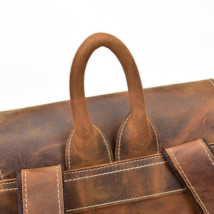 Vintage leather backpack with top handle and stitched seams, distressed brown leather