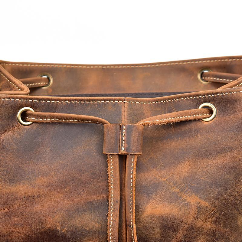 Leather backpack close-up of drawstring cord, grommets, and metal ring details