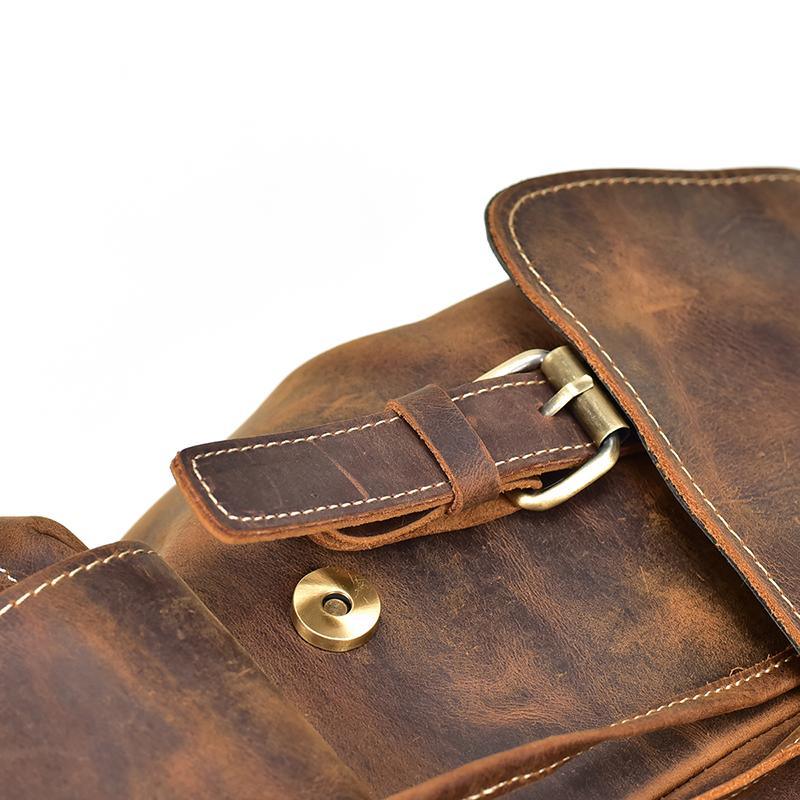 Vintage leather backpack in distressed brown with brass buckle and stitched flap