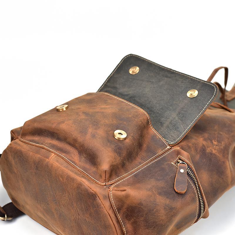 Brown and gray leather backpack with snap buttons and top flap open