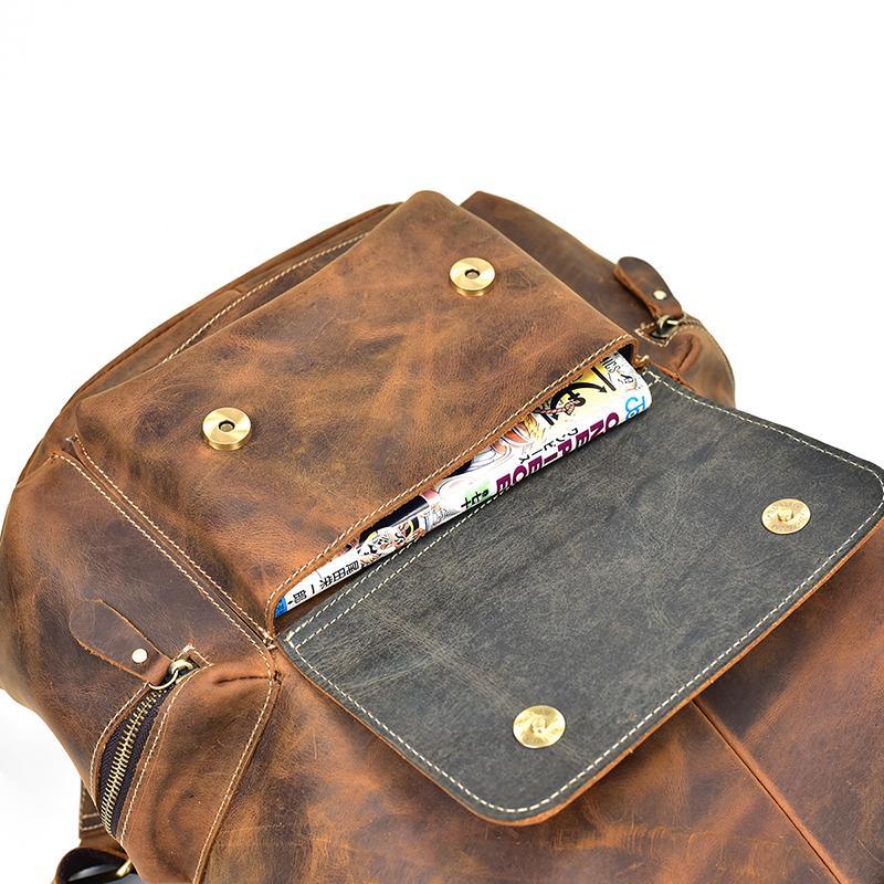 Vintage leather backpack with front pocket and top flap, brown leather with brass snaps