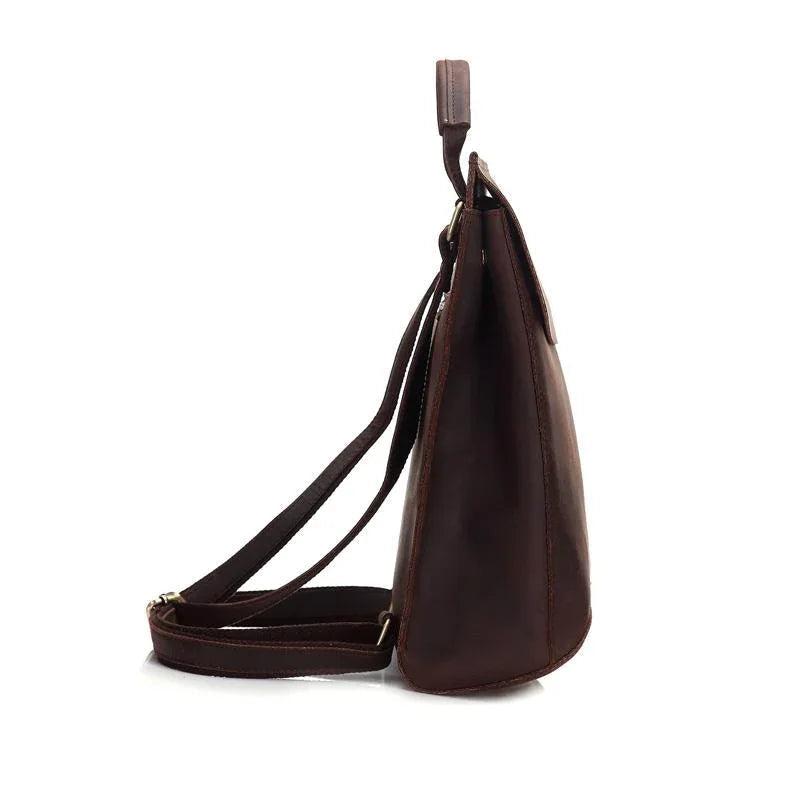 Dark brown leather travel backpack side view with curved handle and crossbody strap