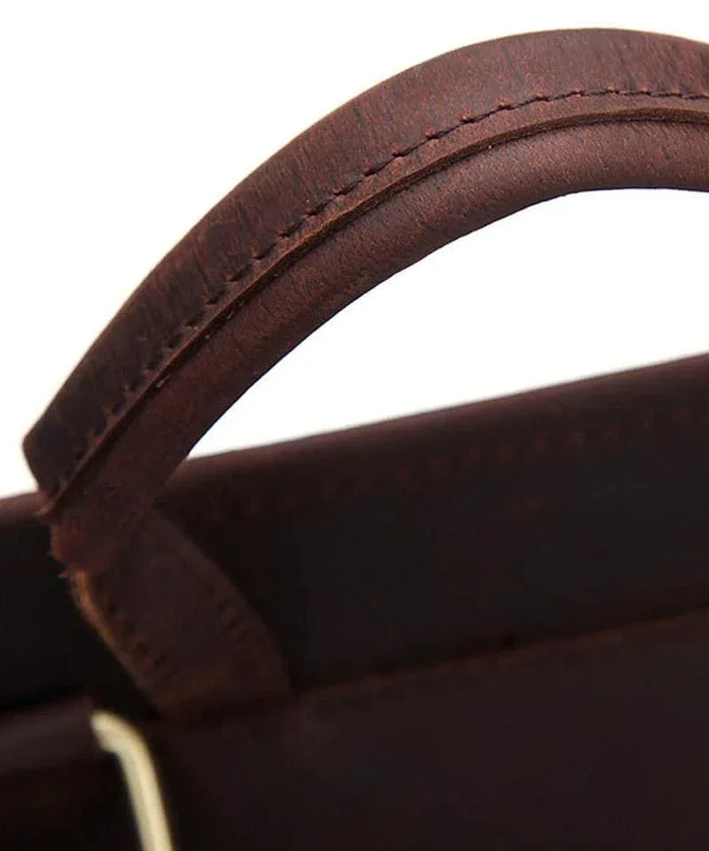 Brown leather top handle with visible stitching along the curved strap