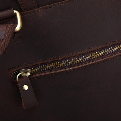 Close-up of dark brown leather zipper pocket with brass-toned hardware and snap tab
