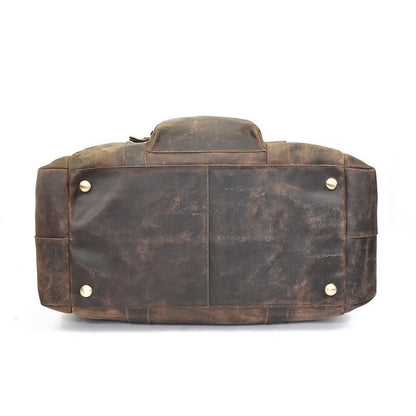 Brown leather duffle bag with snap strap detail and metal hardware, back view.