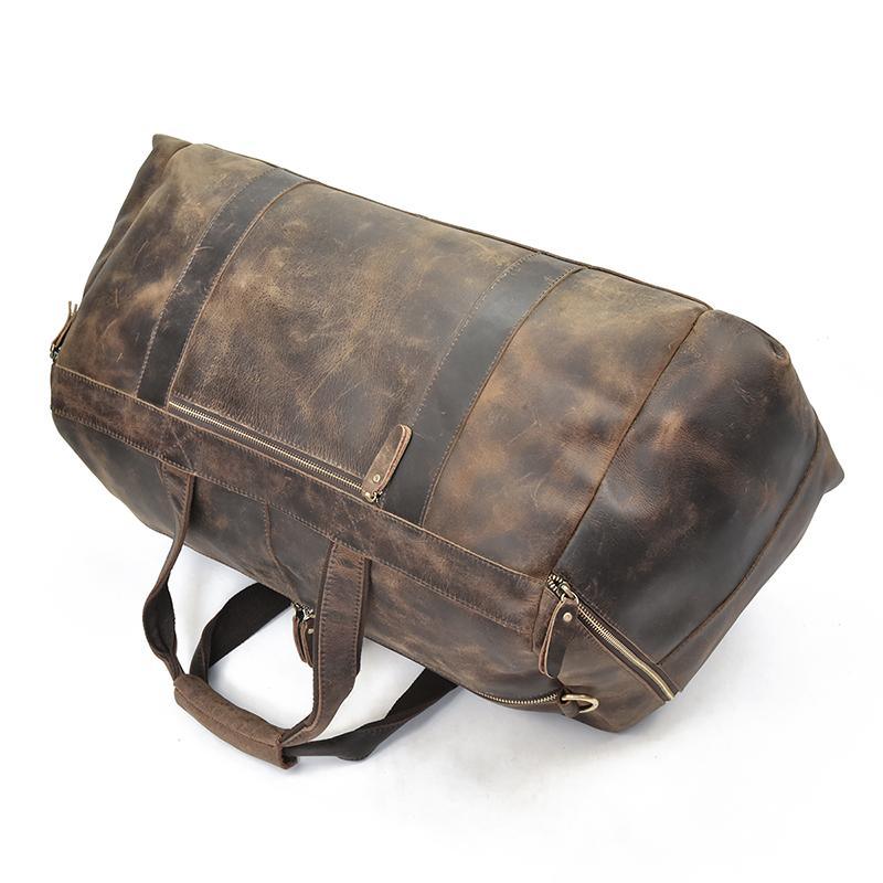 Distressed dark brown leather duffle bag with adjustable shoulder strap and front zip pocket