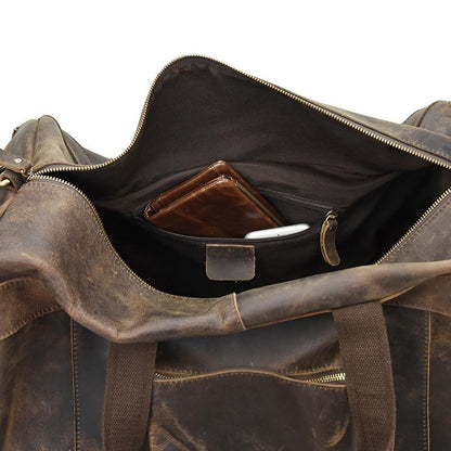 Open brown leather duffle bag showing interior zip pocket and lining.