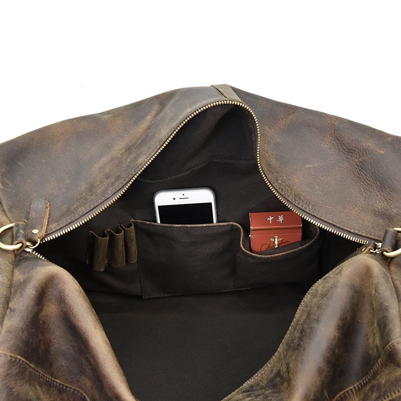 Distressed dark brown leather duffle bag interior with zipper pocket and phone-sized slot