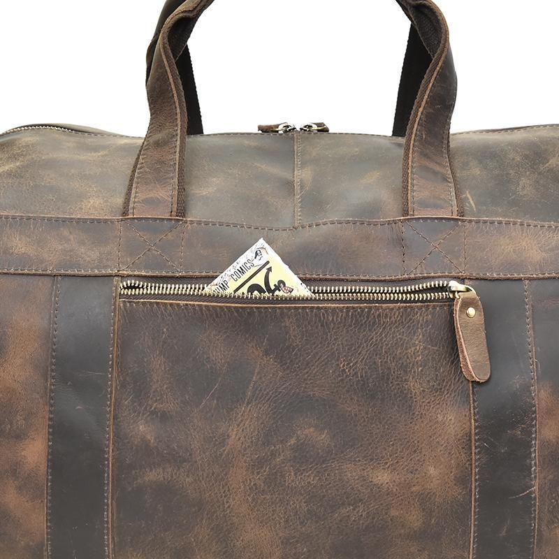 Front zipper pocket of brown leather duffle bag with metal pull tab detail.
