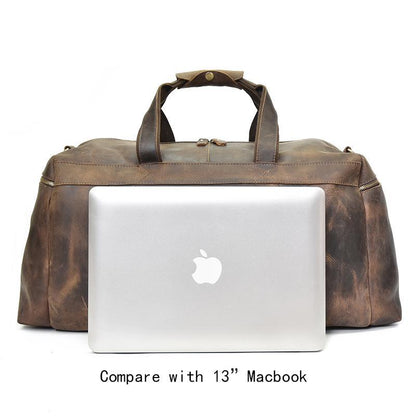 Distressed dark brown leather duffle bag with top handles and zip-top closure