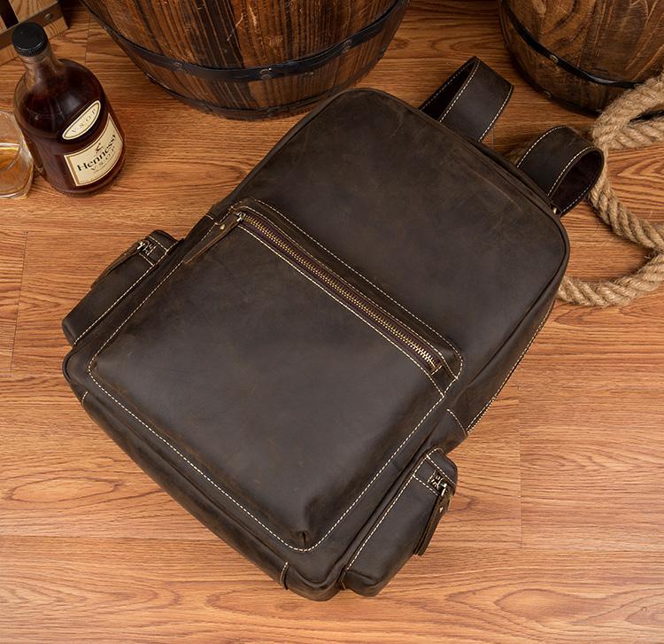 Dark brown leather vintage backpack with front zipper and stitched edges