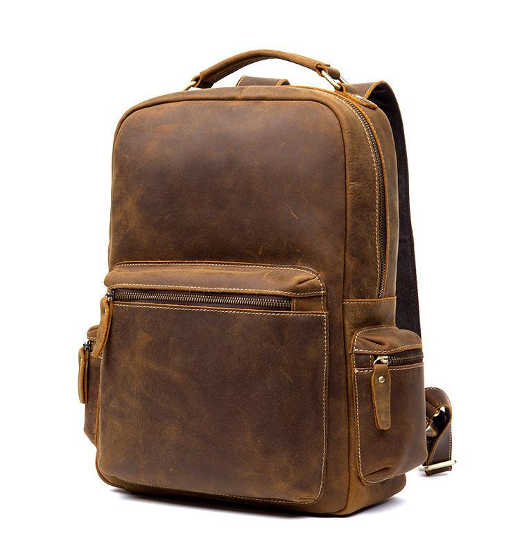 Brown vintage leather backpack with front zip pocket, side accessory pocket, and top handle.