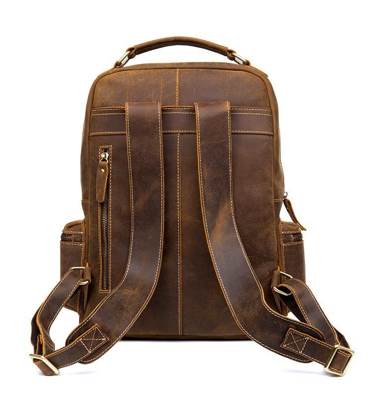 Brown leather vintage backpack with top handle, front pockets, and adjustable straps