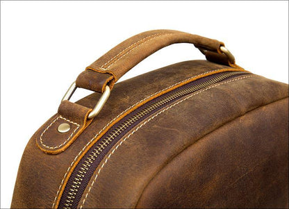 Brown leather vintage backpack with top handle and metal zipper trim