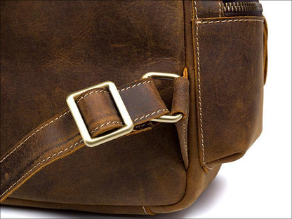 Vintage leather backpack side detail with metal buckle, stitched panel and strap