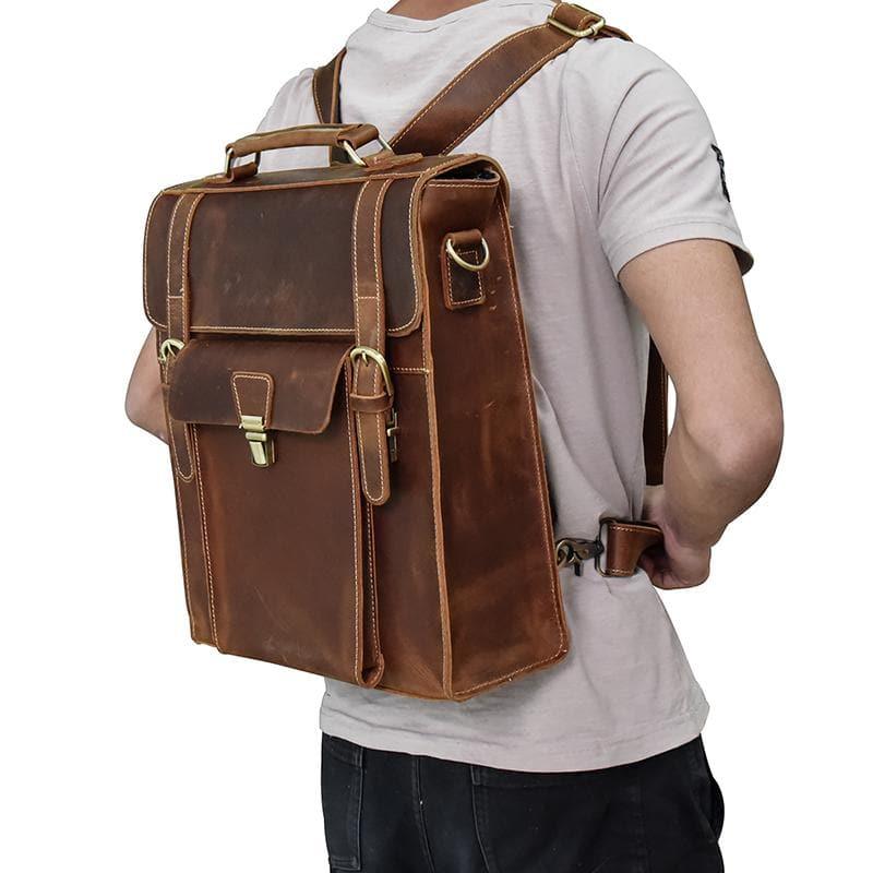 Brown vintage leather backpack with top handle, front flap pockets, and buckle straps