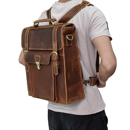 Brown vintage leather backpack with top handle, front flap pockets, and buckle straps