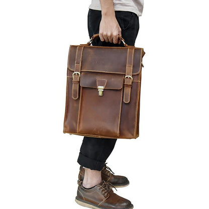 Brown leather backpack with front flap, center buckle latch, and adjustable shoulder straps