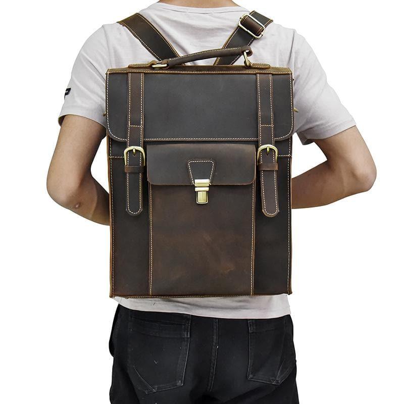 Dark brown leather backpack worn with shoulder straps; front flap with buckle latch