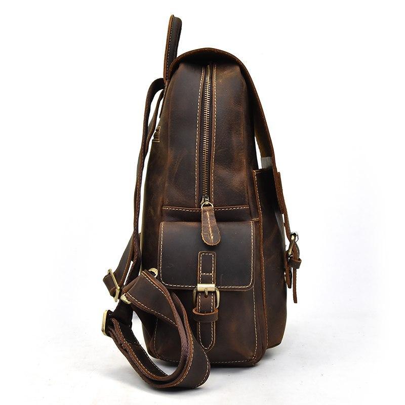 Brown leather backpack side view with zipper, front flap, and adjustable shoulder strap