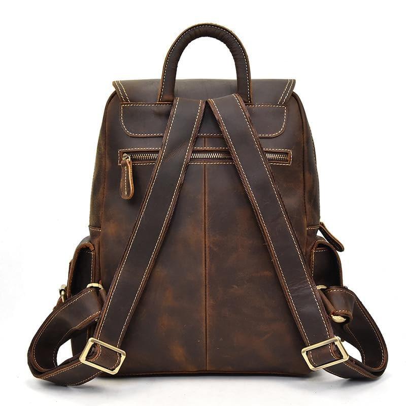 Brown leather backpack with top handle, front flap, and two front zip pockets