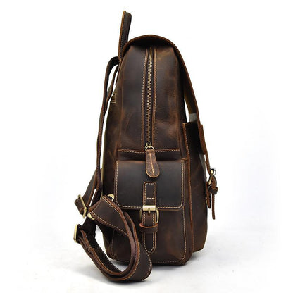 Brown leather backpack back view with zipper, front latch, and adjustable shoulder strap